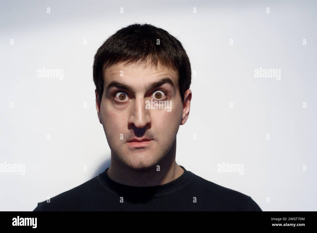 Adult man grimacing with his face and gesturing with his hands Stock Photo