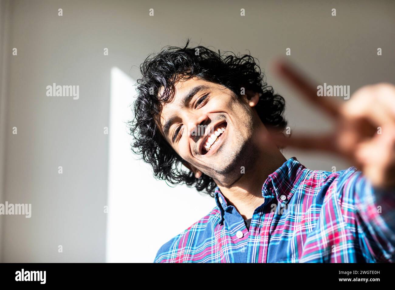 young man at home making signs with the hands Stock Photo