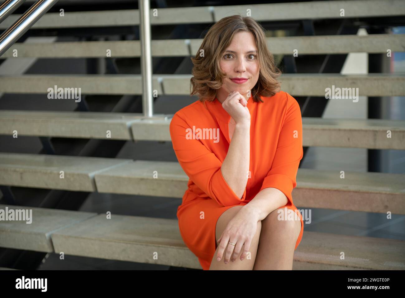 Attractive woman sitting on steps in business wear Stock Photo