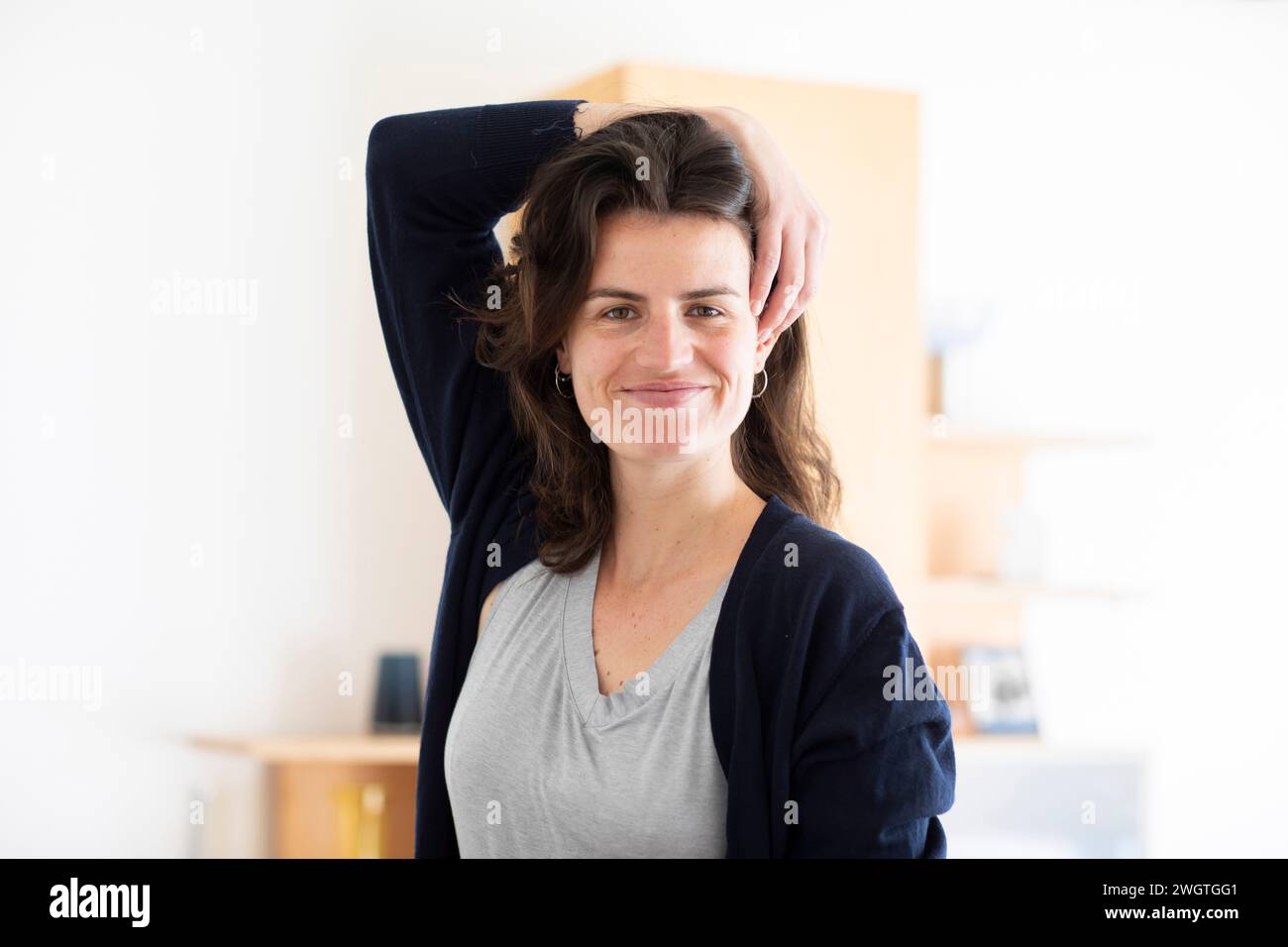 young woman standing in a room, smiling Stock Photo