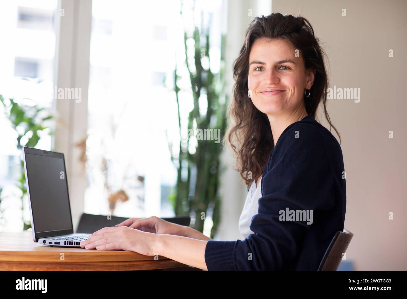 young woman working at home with green plants Stock Photo