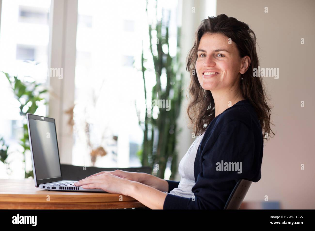 young woman working at home with green plants Stock Photo