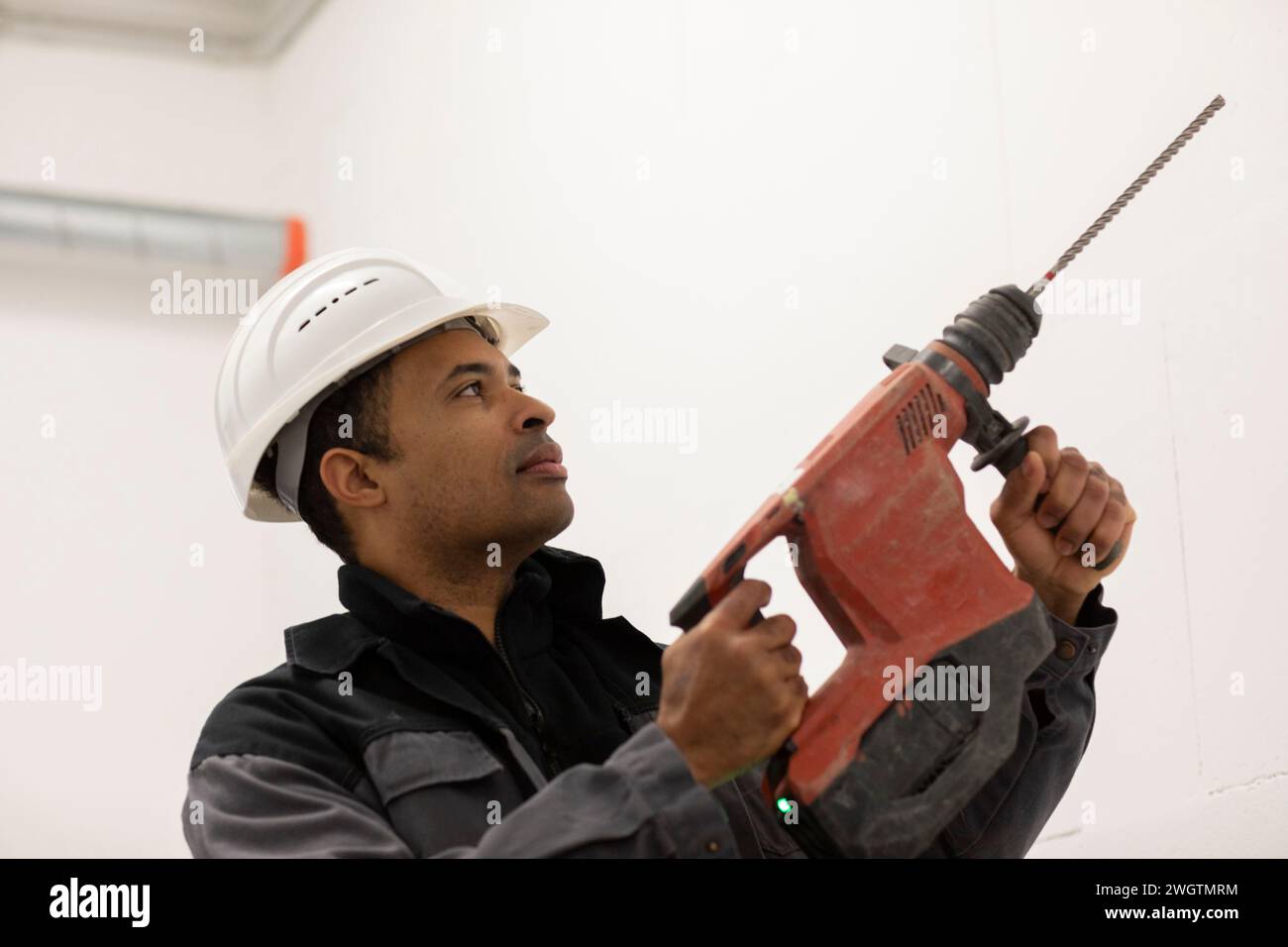 Engineer with helmet, portrait with a drill Stock Photo