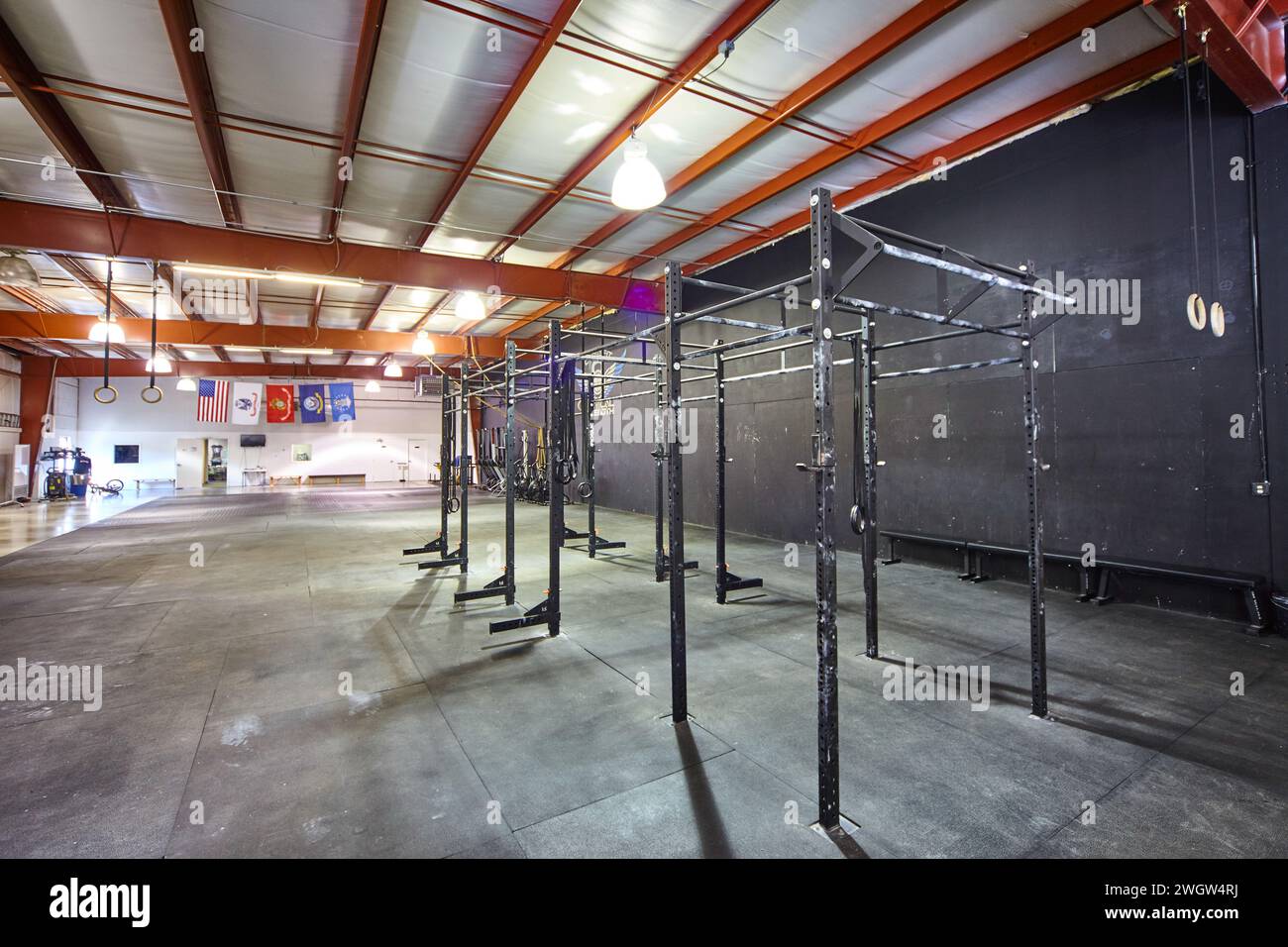 Industrial Gym Interior with Squat Racks and Gymnastic Rings Stock