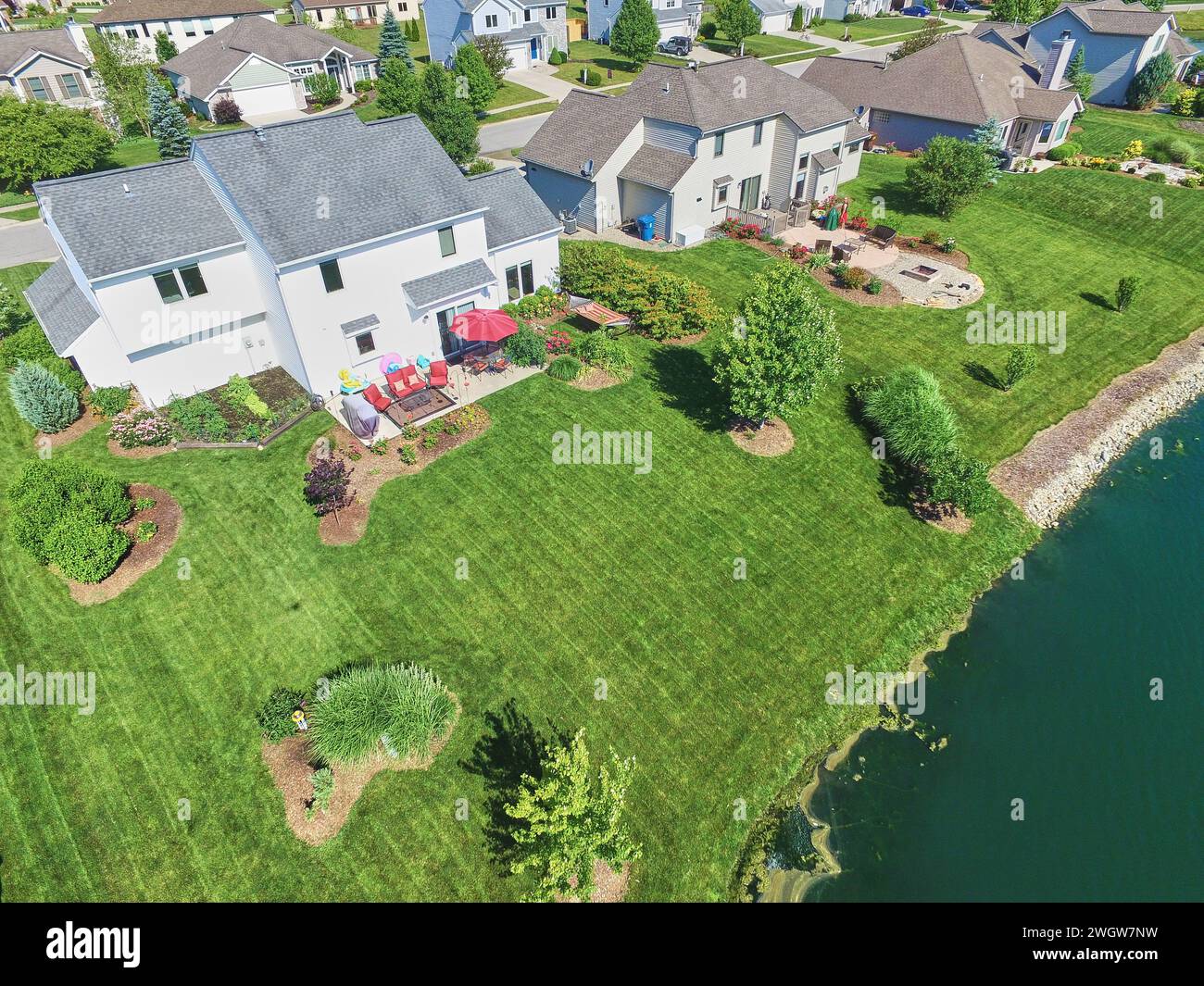 Image showcasing Aerial Sunny Suburban Home with Landscaped Yard and Waterfront Stock ...