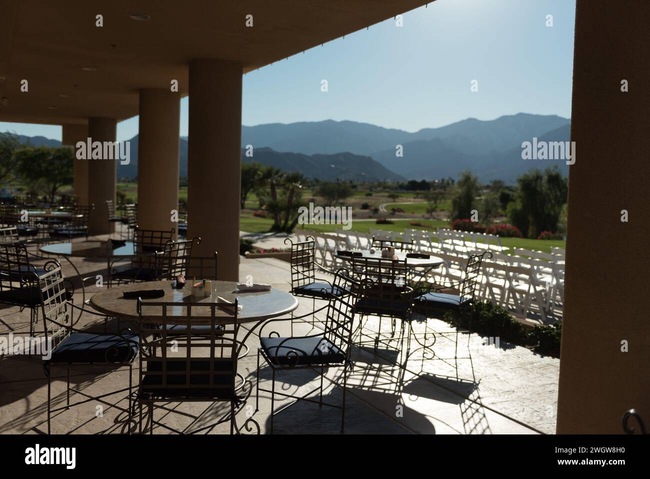 Empty outdoor patio with tables and chairs arranged to offer a picturesque view of the mountains Stock Photo