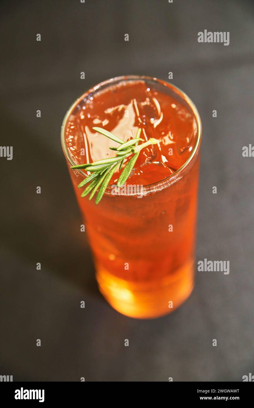 Chilled Amber Beverage with Rosemary Garnish Close-Up Stock Photo