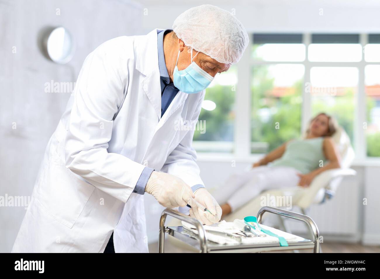 Old male doctor preparing injection for woman patient Stock Photo - Alamy