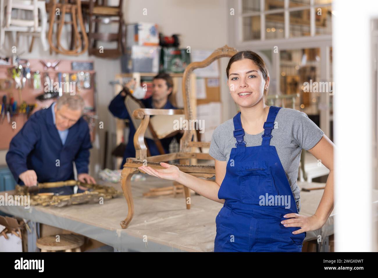 woman restorer spackling antique chair surface getting piece of furniture ready for further coloring Stock Photo
