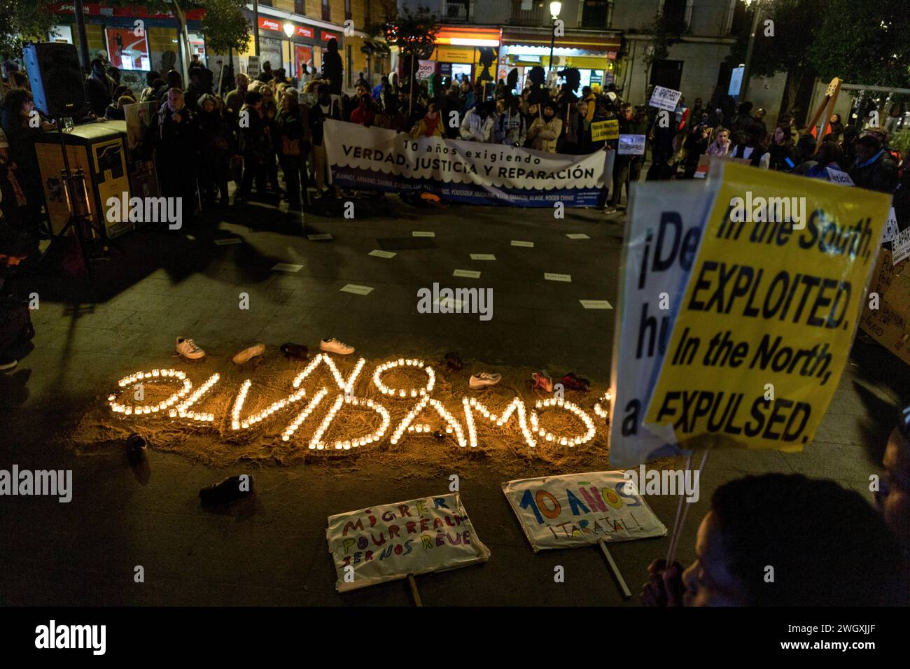 Madrid, Madrid, Spain. 6th Feb, 2024. Activists and neighbors carrying banners, around lighted candles that form the Spanish words ''No Olvidamos'', during a rally in the Lavapies neighborhood of Madrid to commemorate the 14 fatalities of the El Tarajal tragedy. On February 6, 2014, the Spanish Civil Guard used riot gear to prevent migrants from swimming in Spanish territory, where 14 people drowned to death. (Credit Image: © Luis Soto/ZUMA Press Wire) EDITORIAL USAGE ONLY! Not for Commercial USAGE! Stock Photo