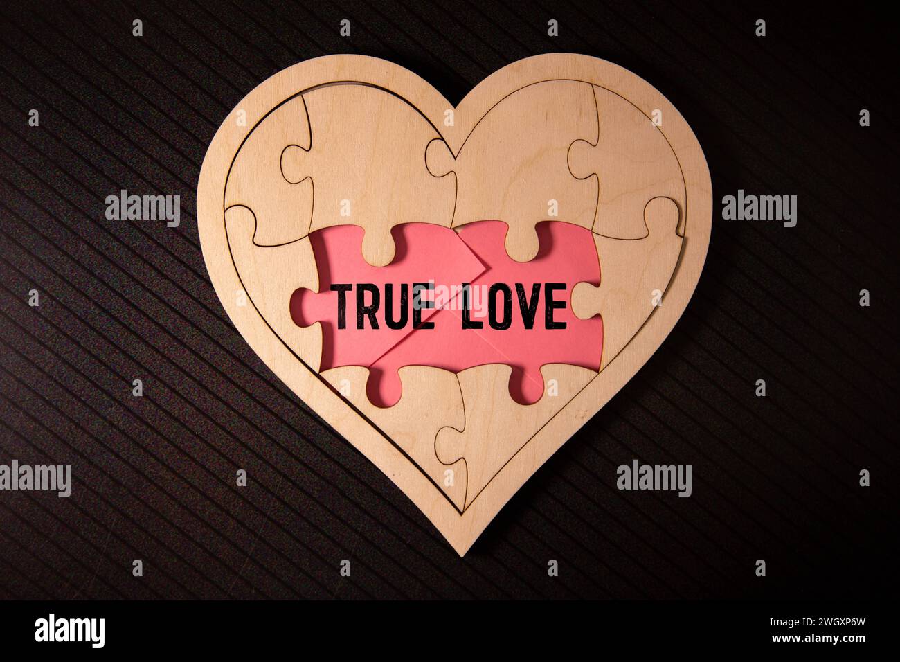 The text True Love appearing behind torn brown paper. Stock Photo