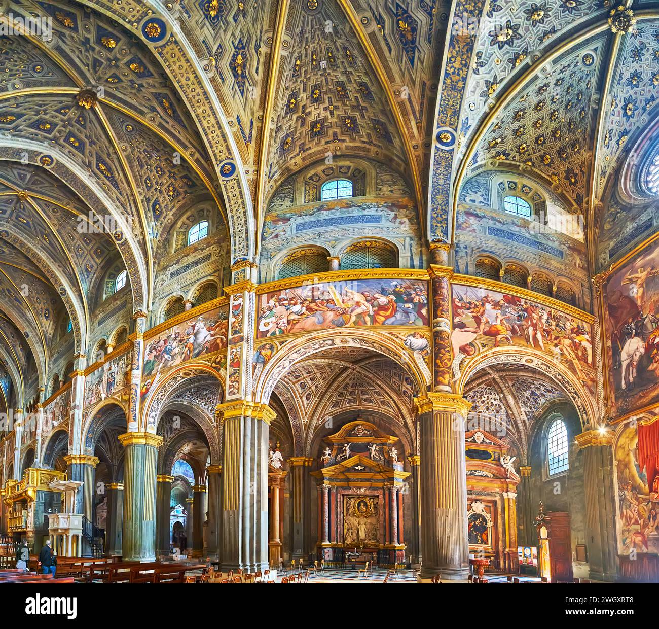 CREMONA, ITALY - APRIL 6, 2022: The frescoed interior of medieval Santa Maria Assunta Cathedral with tall walls, columns, arcades and rib-vaulted ceil Stock Photo