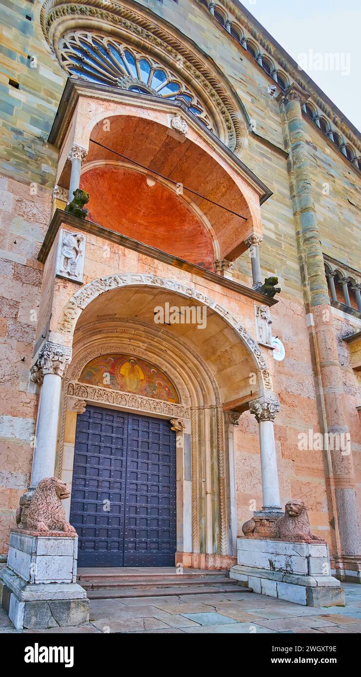 The main gate of Piacenza Cathedral is decorated with frescoe, stone carvings, slender pillars and sculptures of lions, Italy Stock Photo