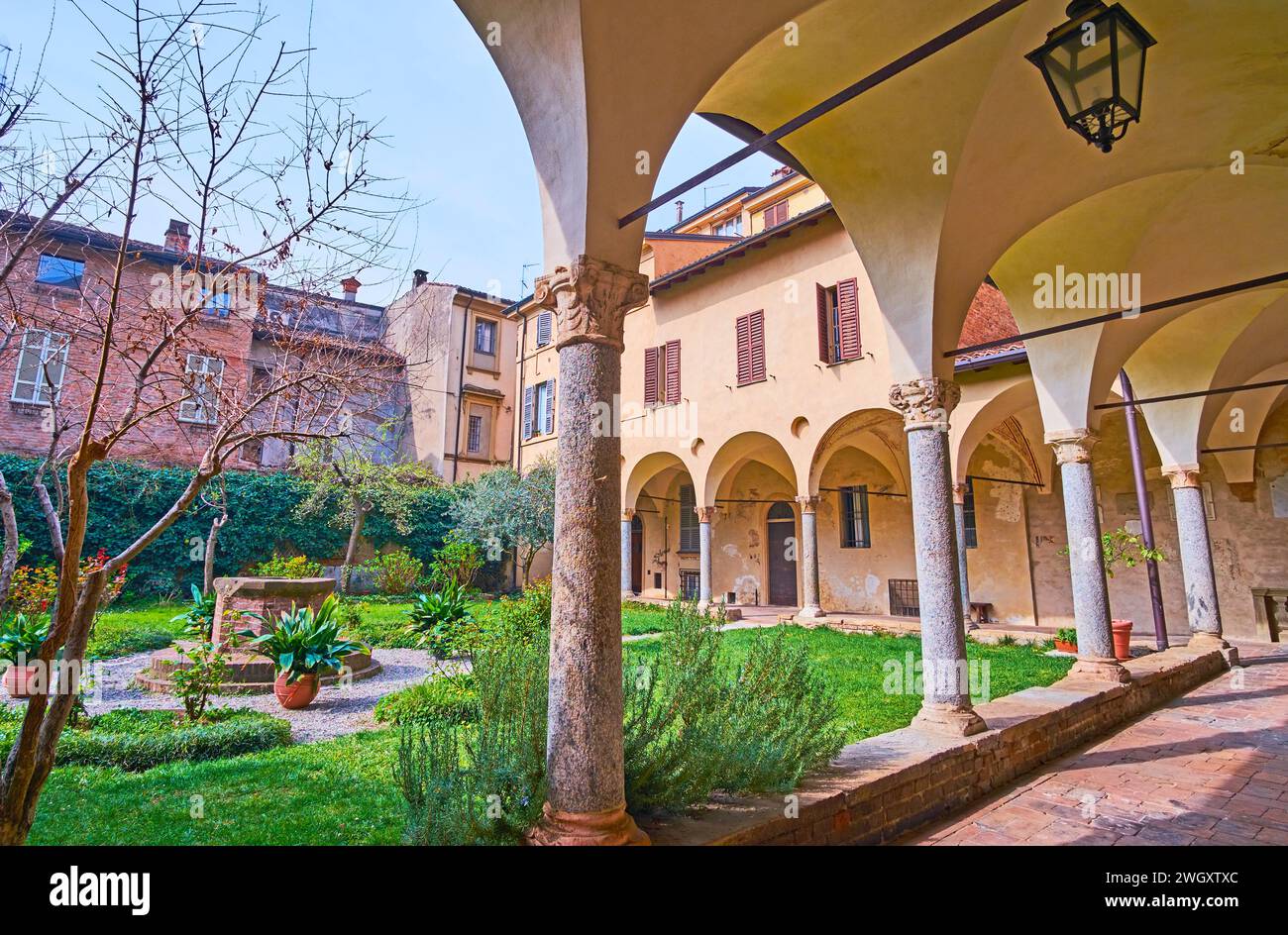Panorama of the small cloister of St Antoninus Basilica with green garden and shady arcades, Piacenza, Italy Stock Photo