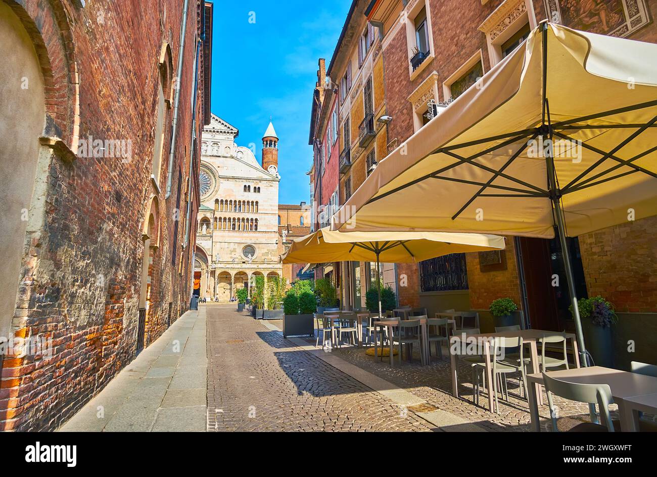 The narrow Via dei Gonfalonieri street with small restaurants and a view on Cremona Cathedral, Italy Stock Photo