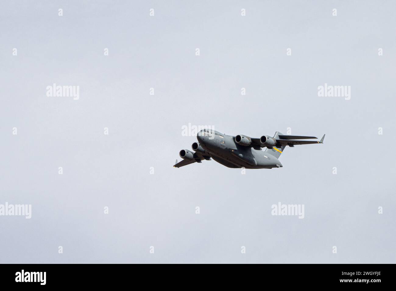 A U.S. Air Force C-17 Globemaster III, left, assigned to the 97th Air Mobility Wing, flies above Fort Huachuca, Arizona, during Winter Training at the Advanced Airlift Tactics Training Center, January 25, 2024. Winter Training is a break from the regular course schedule where the instructors of AATTC tweak the training scenarios for the coming year and perform them, with the help of guest units, to keep their skills fresh. Since 1983 the AATTC has provided advanced tactical training to mobility aircrews from the Air National Guard, Air Force Reserve Command, Air Mobility Command, Air Combat Co Stock Photo