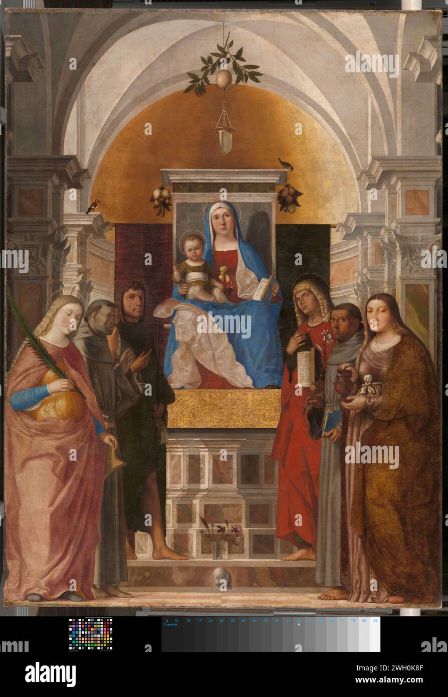 Madonna and Child with Sts Catherine, Francis of Assisi, John the Baptist, John the Evangelist, Antony of Padua and Mary Magdalene, Marcello Fogolino, 1510 - 1520 painting Mary with child and saints. Church interior with Mary in the middle with the Christ child and a book sitting on a raised throne. On the left the saints Catharina, Franciscus and Johannes the Baptist. On the right the Saints Mary Magdalena, Antonius van Padua and John the Evangelist. On the step in front of the throne is a glass vase with a few flowers, on the corners of the throne hang bunches with fruit.  canvas. oil paint Stock Photo