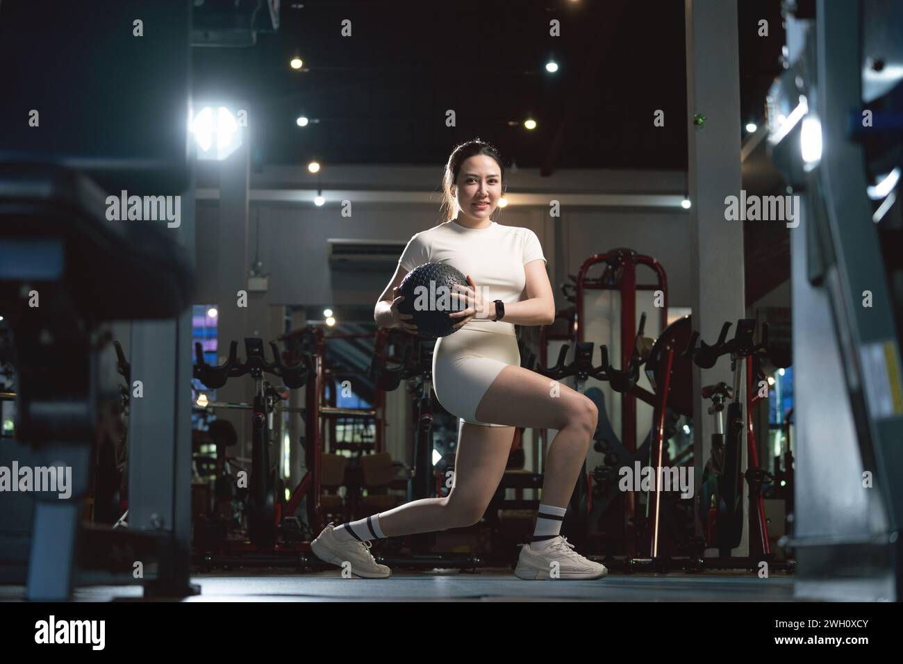 Young asian woman is working out with balls in gym. Stock Photo