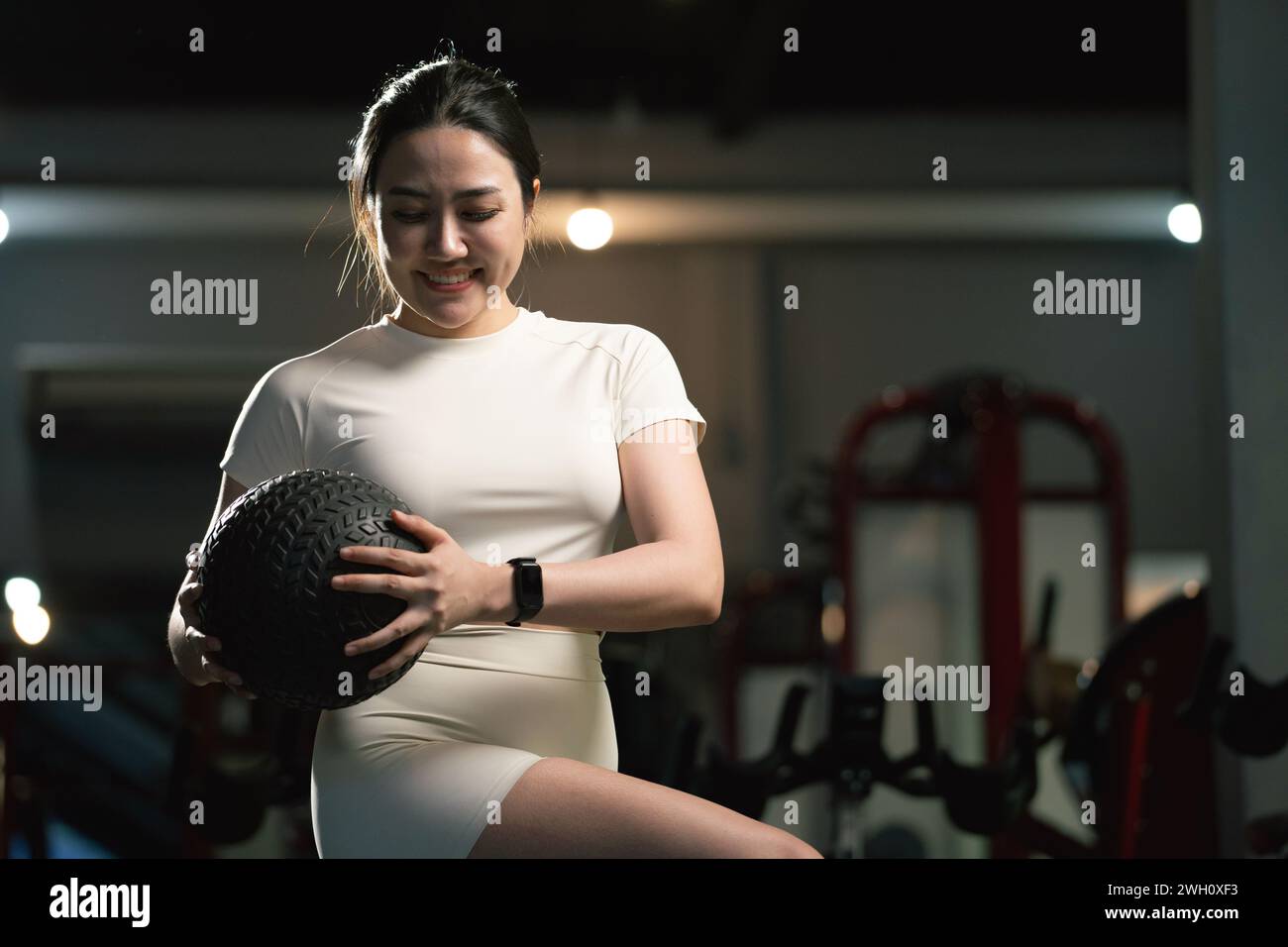 Young asian woman is working out with balls in gym. Stock Photo