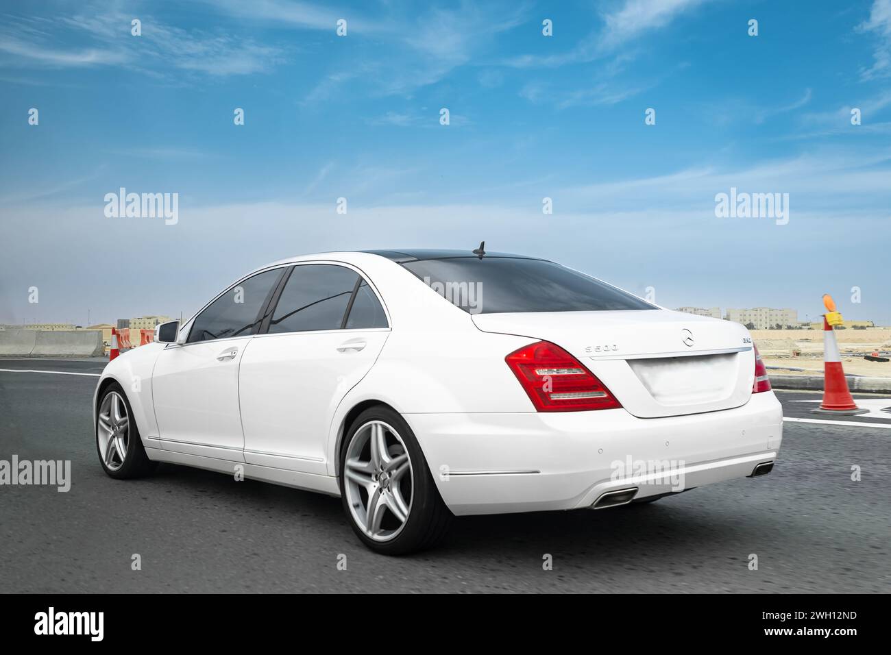 White Mercedes S500 on a test drive on a high way. Produced by the German automobile manufacturer Mercedes-Benz Group AG. Sport car. Luxury lifestyle- Stock Photo