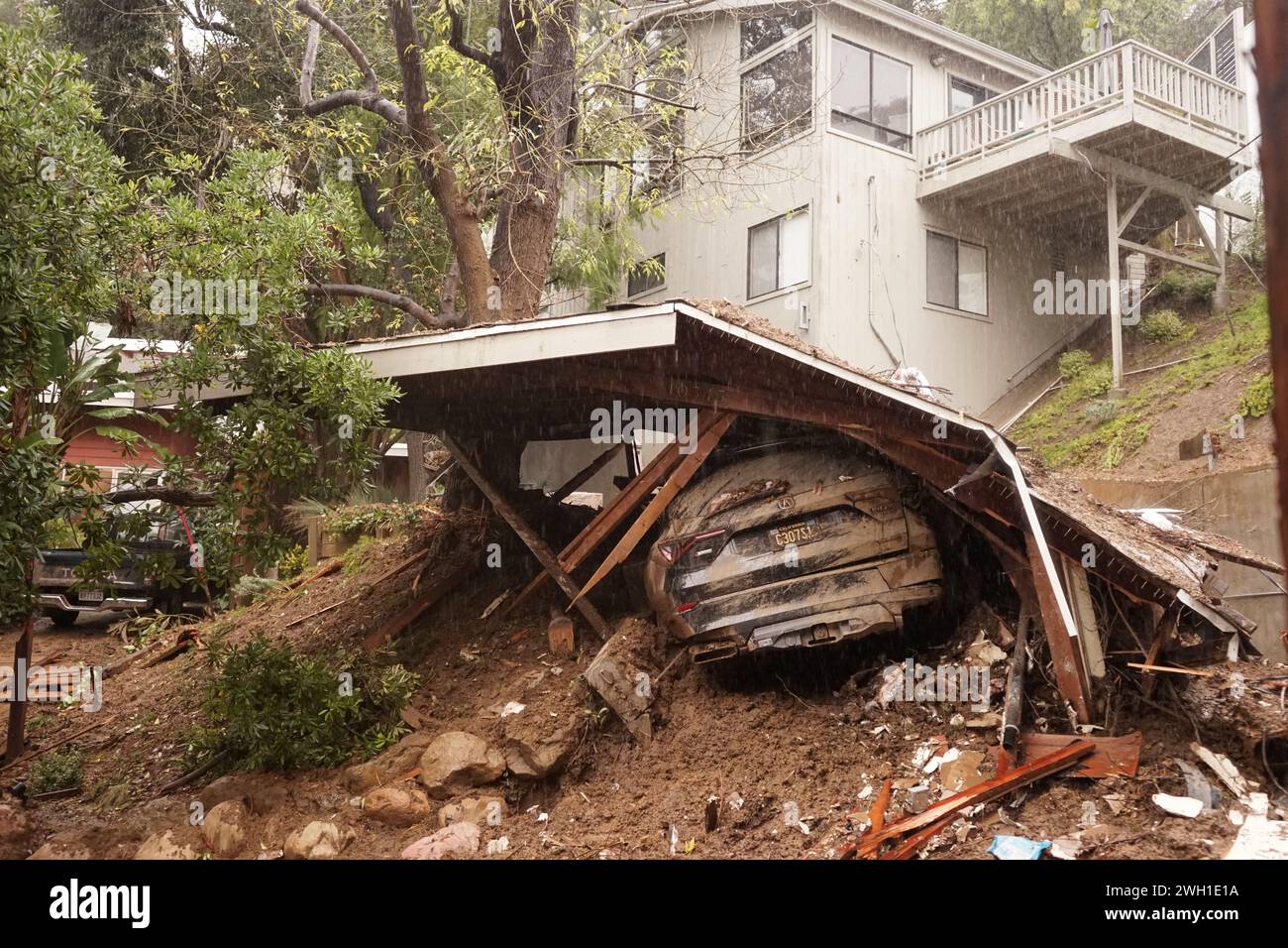 Los Angeles, USA. 6th Feb, 2024. This photo taken on Feb. 6, 2024 shows a damaged car beneath a destroyed house after a severe storm at West Hollywood in Los Angeles, California, the United States. A severe storm system struck California on Saturday, resulting in at least three fatalities, nearly 140,000 people without power, and millions under flood alerts as of Tuesday. The storm unleashed mudslides, flooded roadways, and triggered widespread power outages. Credit: Zeng Hui/Xinhua/Alamy Live News Stock Photo