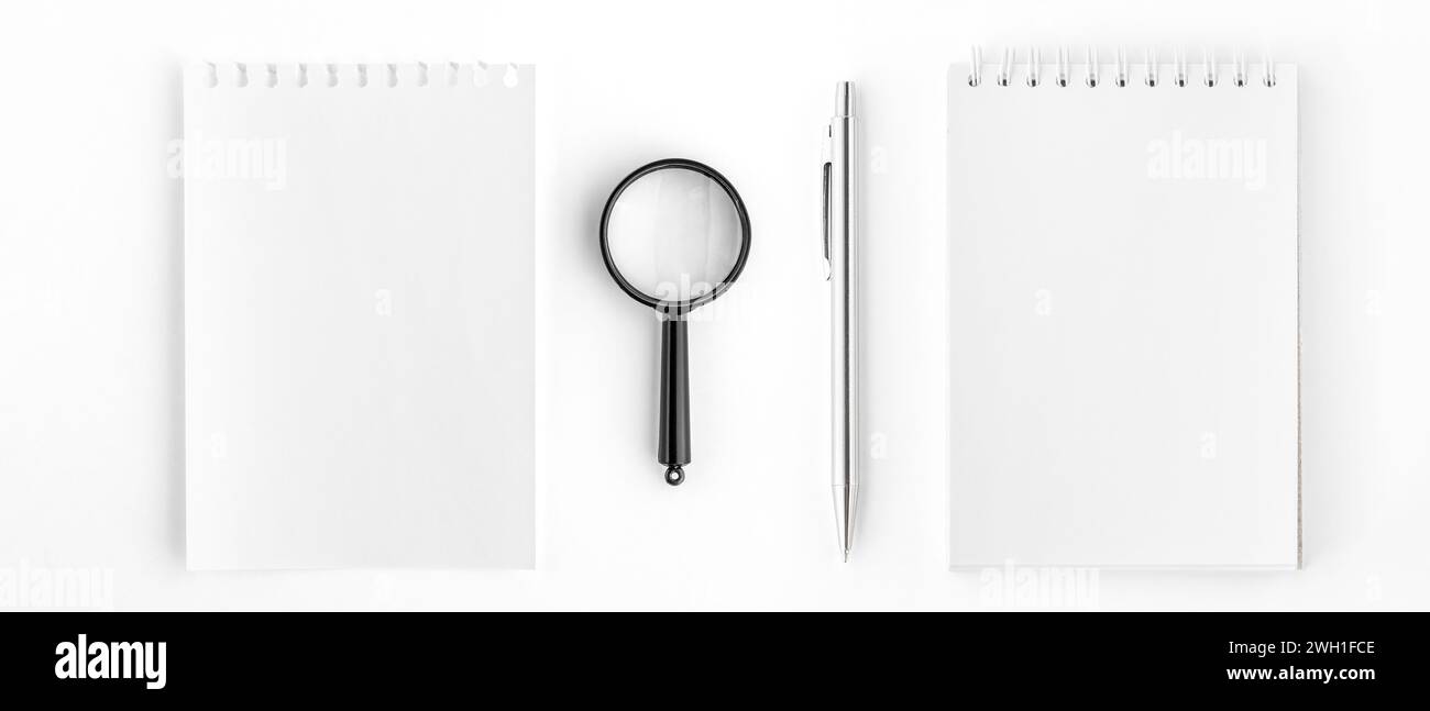 Spiral Notepad and Notepad Page with Pen and Magnifying Glass Stock Photo