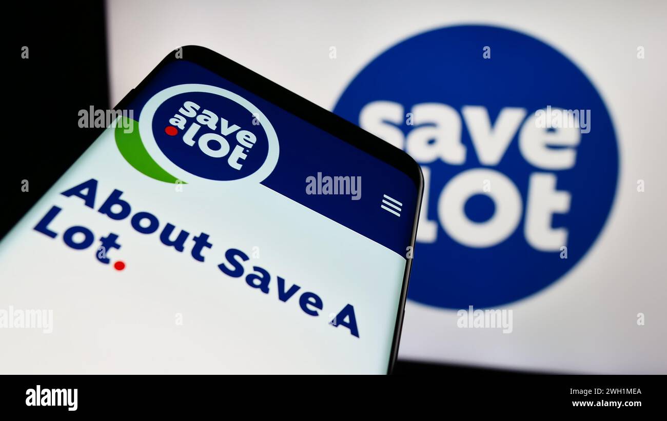 Mobile phone with website of US supermarket company Save A Lot Food Stores Ltd. in front of business logo. Focus on top-left of phone display. Stock Photo