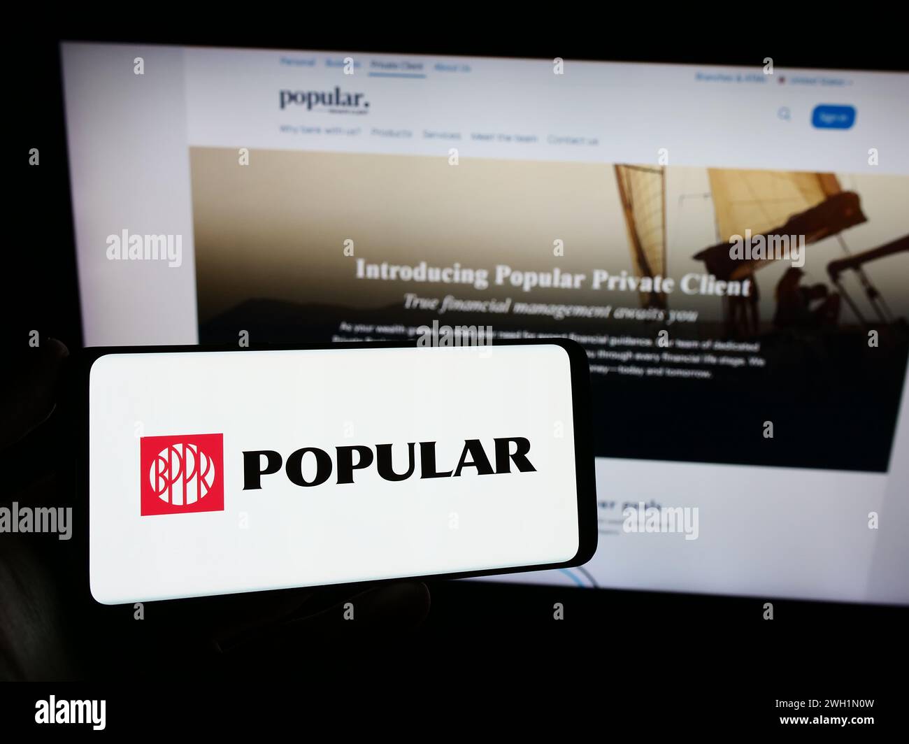 Person holding cellphone with logo of financial services company Banco