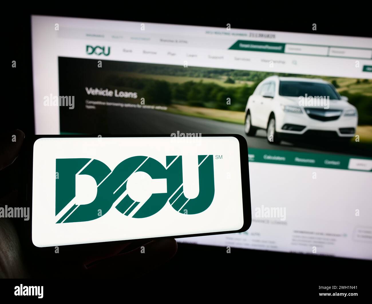 Person holding mobile phone with logo of financial institution Digital