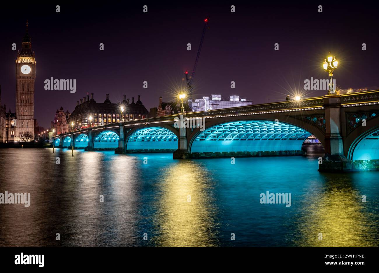 London. UK- 02.04.2024. A night time long exposure view of Westminster Bridge with Big Ben at the end and light reflections on the River Thames. Stock Photo