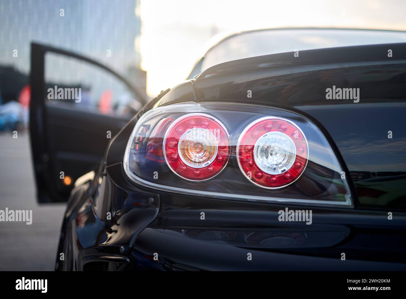 Berlin, Germany - August 20, 2022: Car Detail Shot of Mazda RX-8. Rearlight of black metallic car shot closeup with opened door out of focus Stock Photo