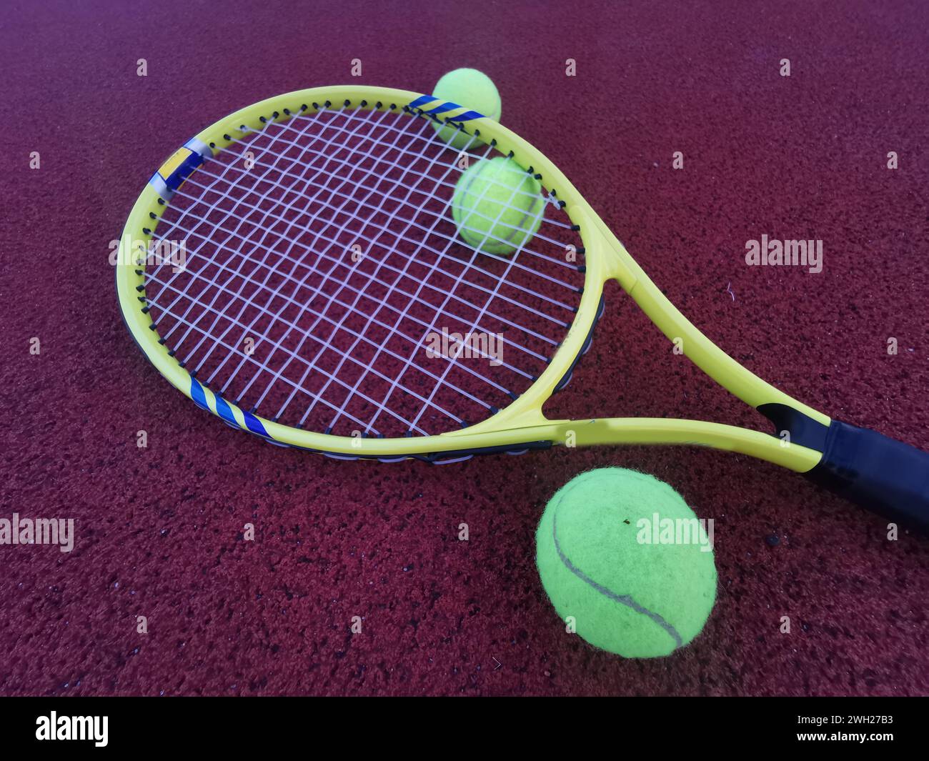 yellow tennis balls and racquet on hard tennis court surface, top view ...