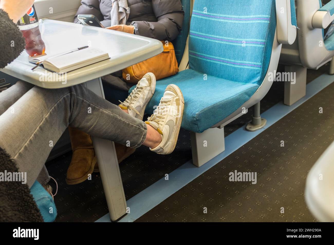 Female passenger's feet on train seat, UK Stock Photo