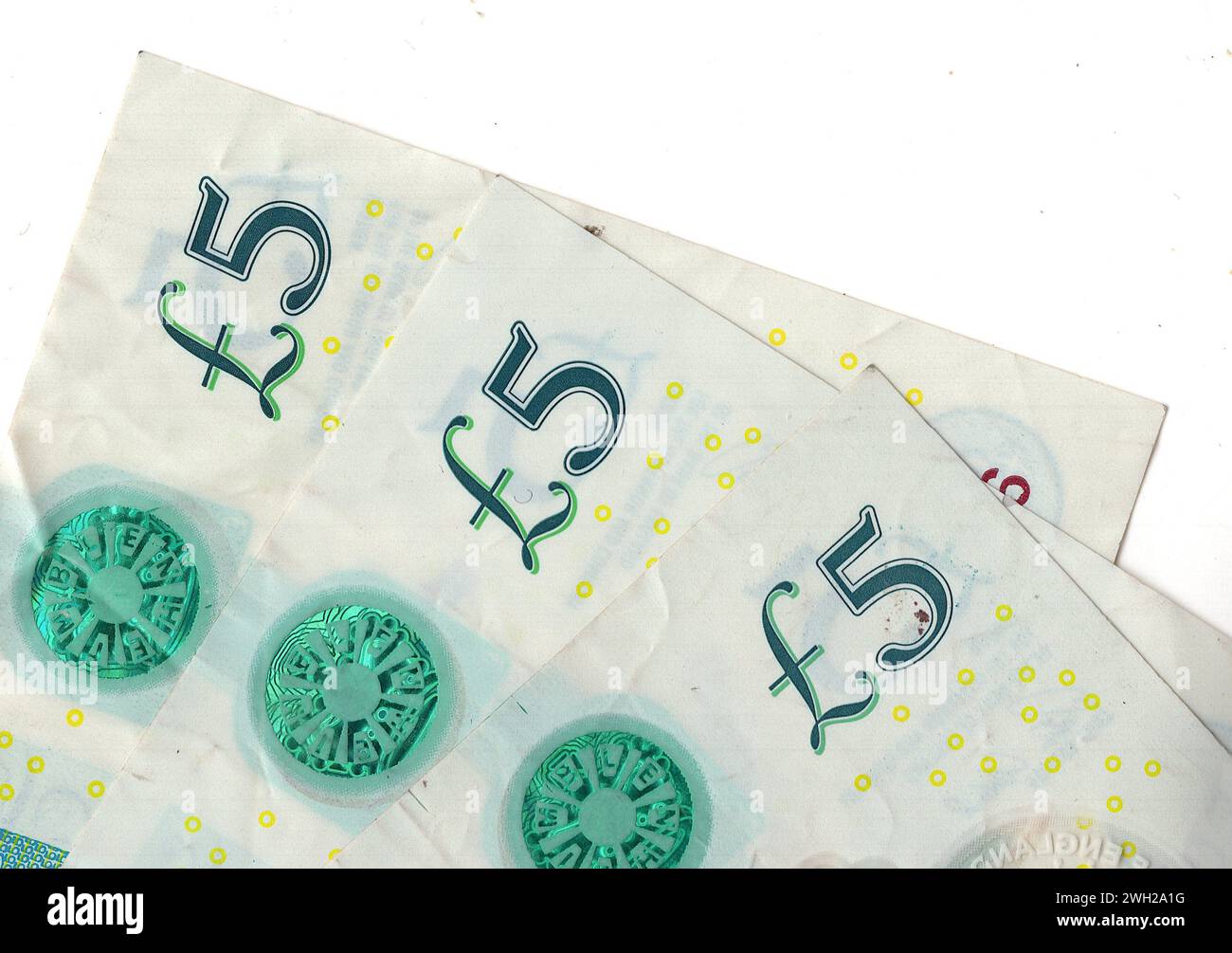 A close up of five pound notes from the United Kingdom isolated on a ...