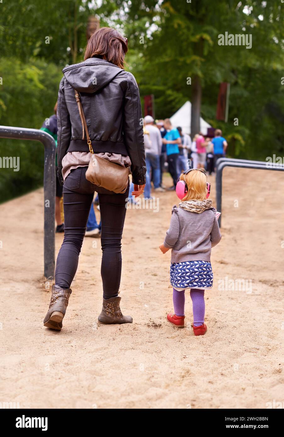 Festival, queue and mother with daughter in forest for event, party or social gathering outdoor in summer. Family, kids and woman parent with girl Stock Photo