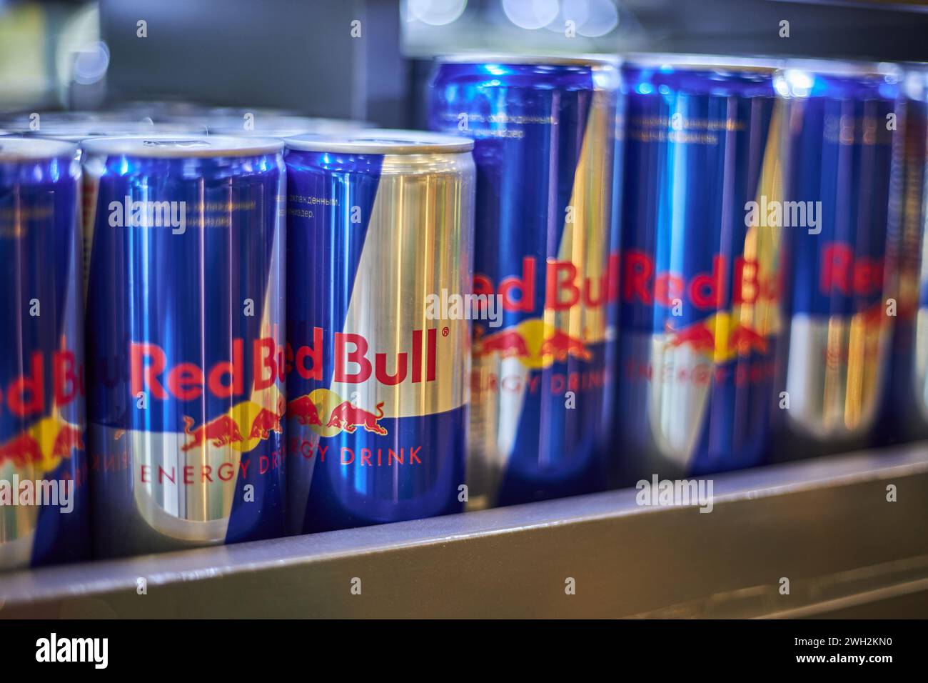Aluminum cans of Red Bull soda energy drink of different sizes and volumes on a shelf in store. Retail, beverage editorial. Bishkek, Kyrgyzstan - 26 M Stock Photo