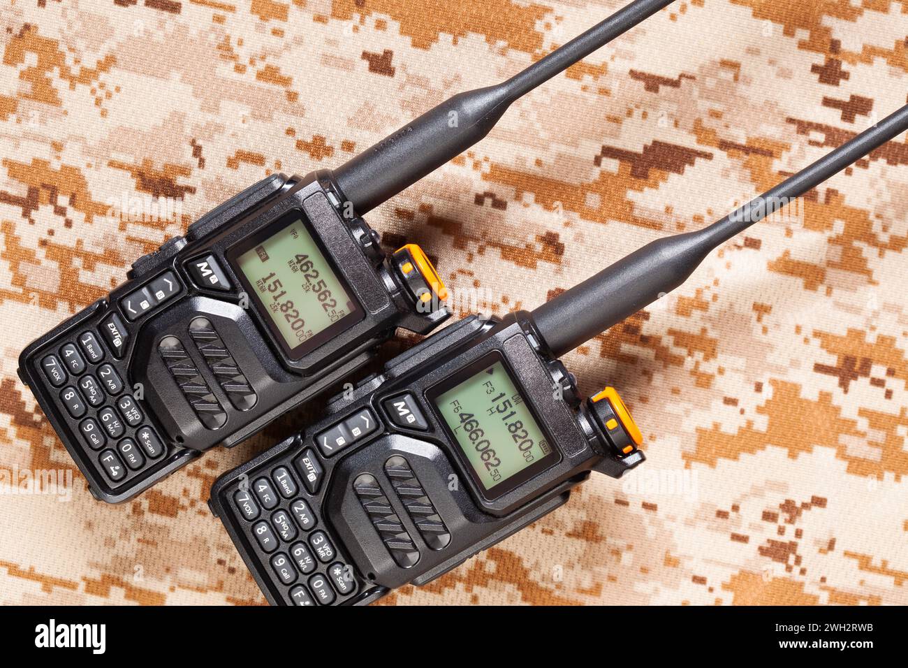 Pair of VHF UHF two-way radios on green camouflage background Stock Photo