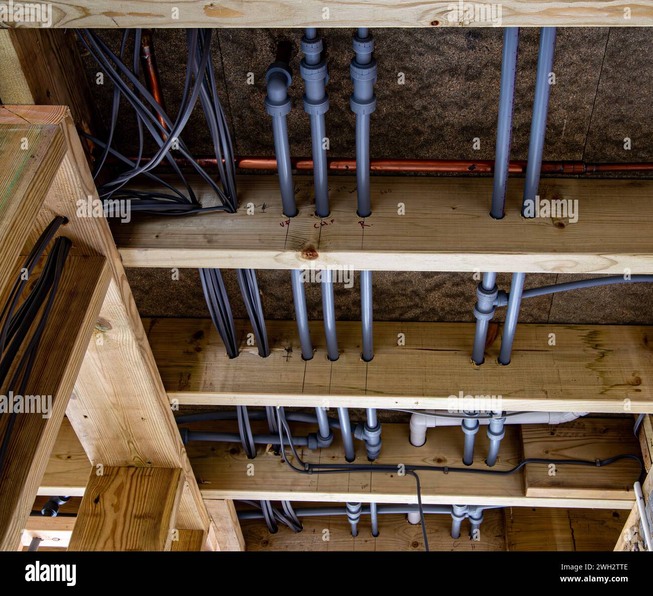 Water pipes and electrical cables in ceiling joists before plasterboard