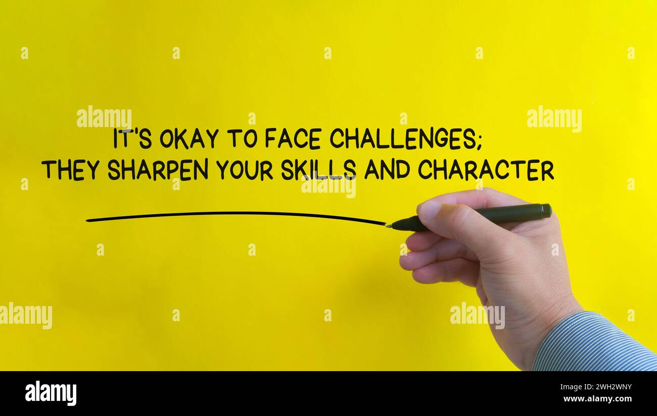 Hand writing It is okay to face challenges affirmation on yellow cover background. Affirmation concept Stock Photo