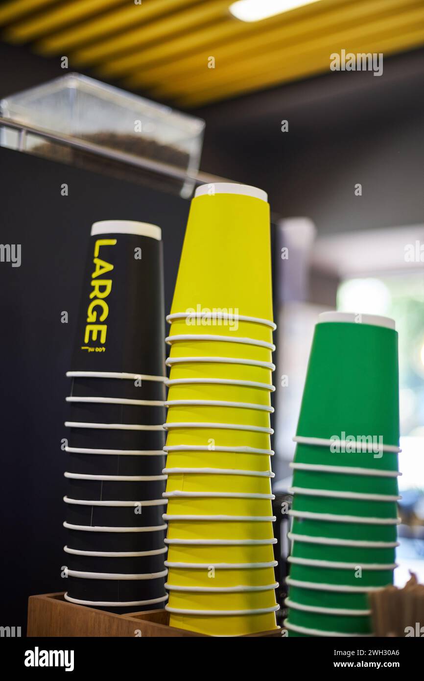 Colored paper cups, black large, yellow medium, green small cup different sizes for hot drinks coffee, tea to take away. Mockup for coffee shop, store Stock Photo