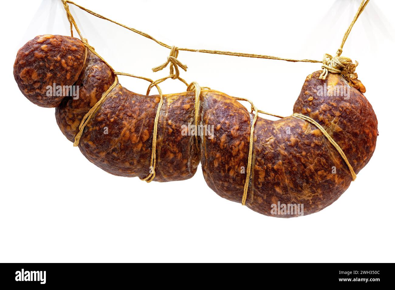 Traditional smoked sausage hanging on ropes on white background Stock ...