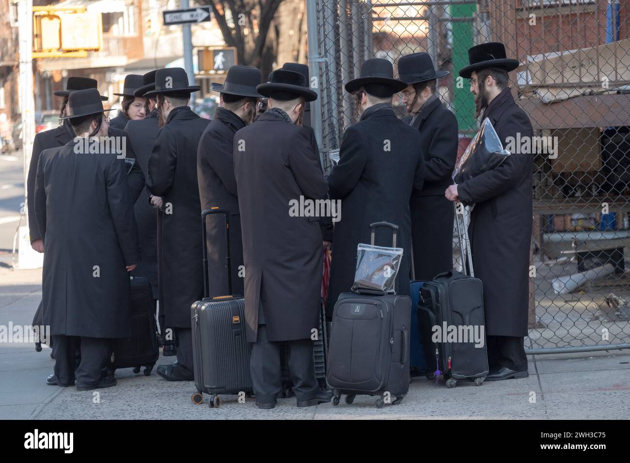 On a cold winter day, a group of Satmar orthodox Jews wait for a bus to take them to a Talmud studies class in another part of Brooklyn, New York. Stock Photo
