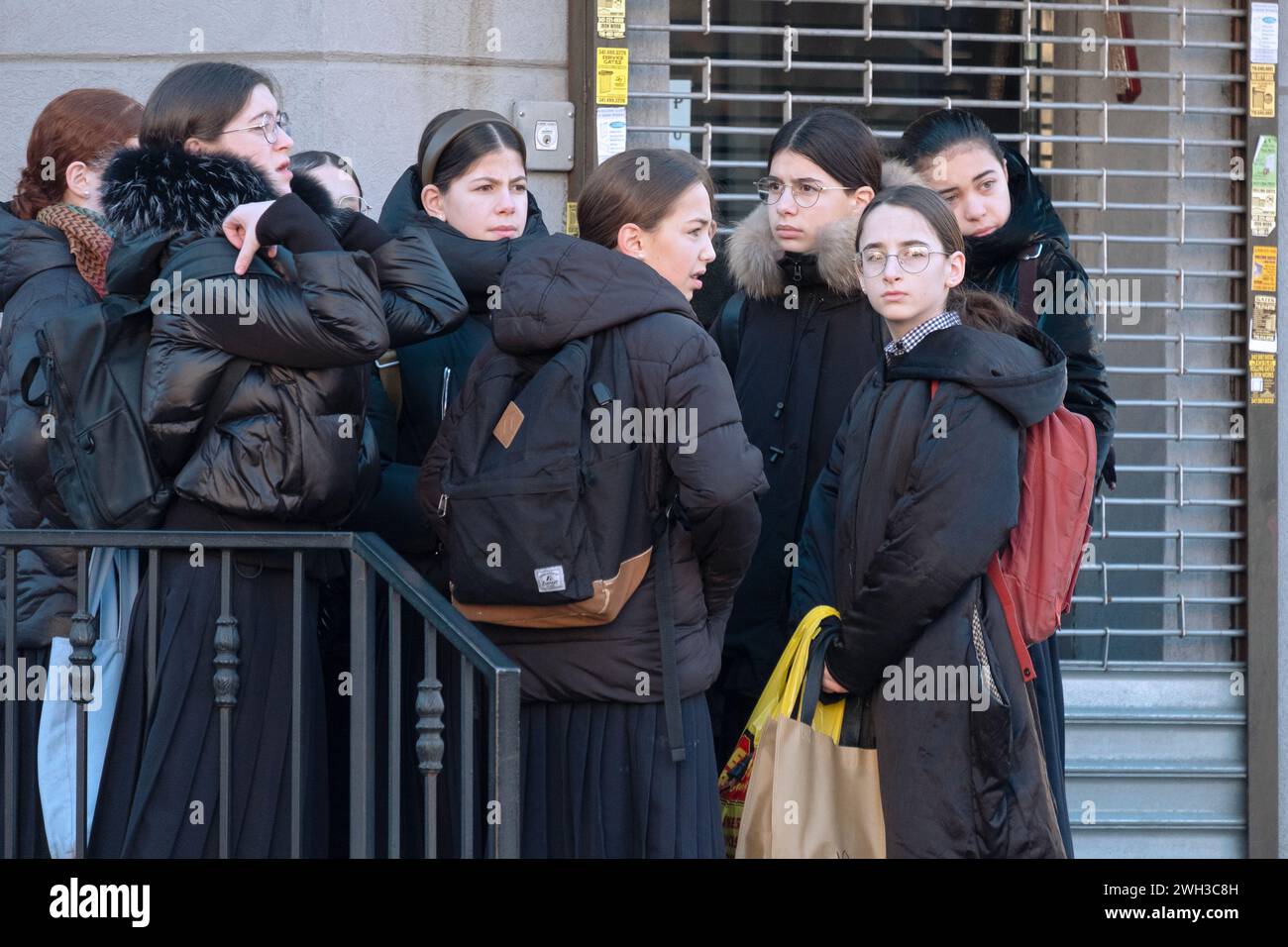 On a cold winter day a group of orthodox Hasidic gorls wait for a bus to takle them to school. On Lee Avenue in Williamsburg, Brooklyn, New Yrok. Stock Photo