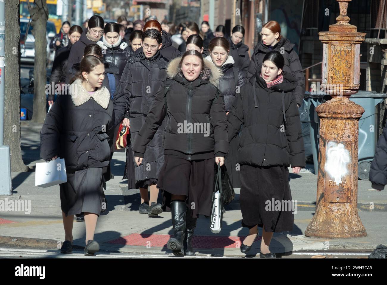 Modestly dressed orthodox Jewish girls go to school on a winter Sunday morning Stock Photo