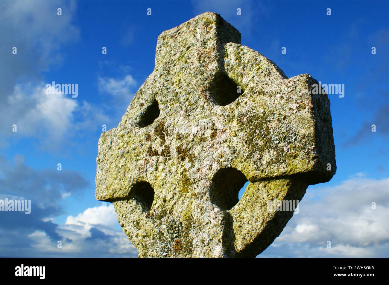 Stone cross. Old Celtic cross on sky background. Stock Photo