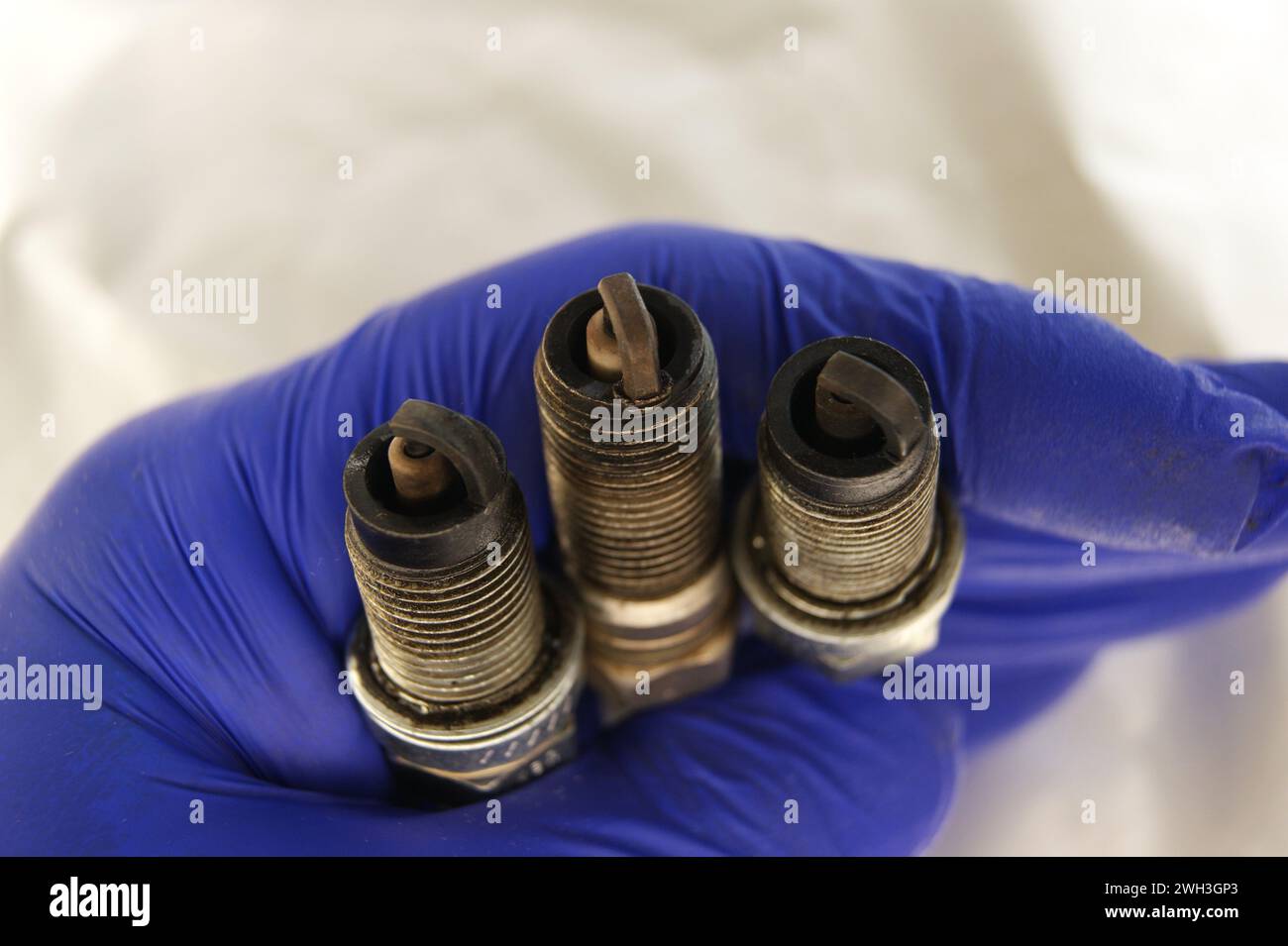 Used gasoline engine spark plugs in mechanic's hand Stock Photo
