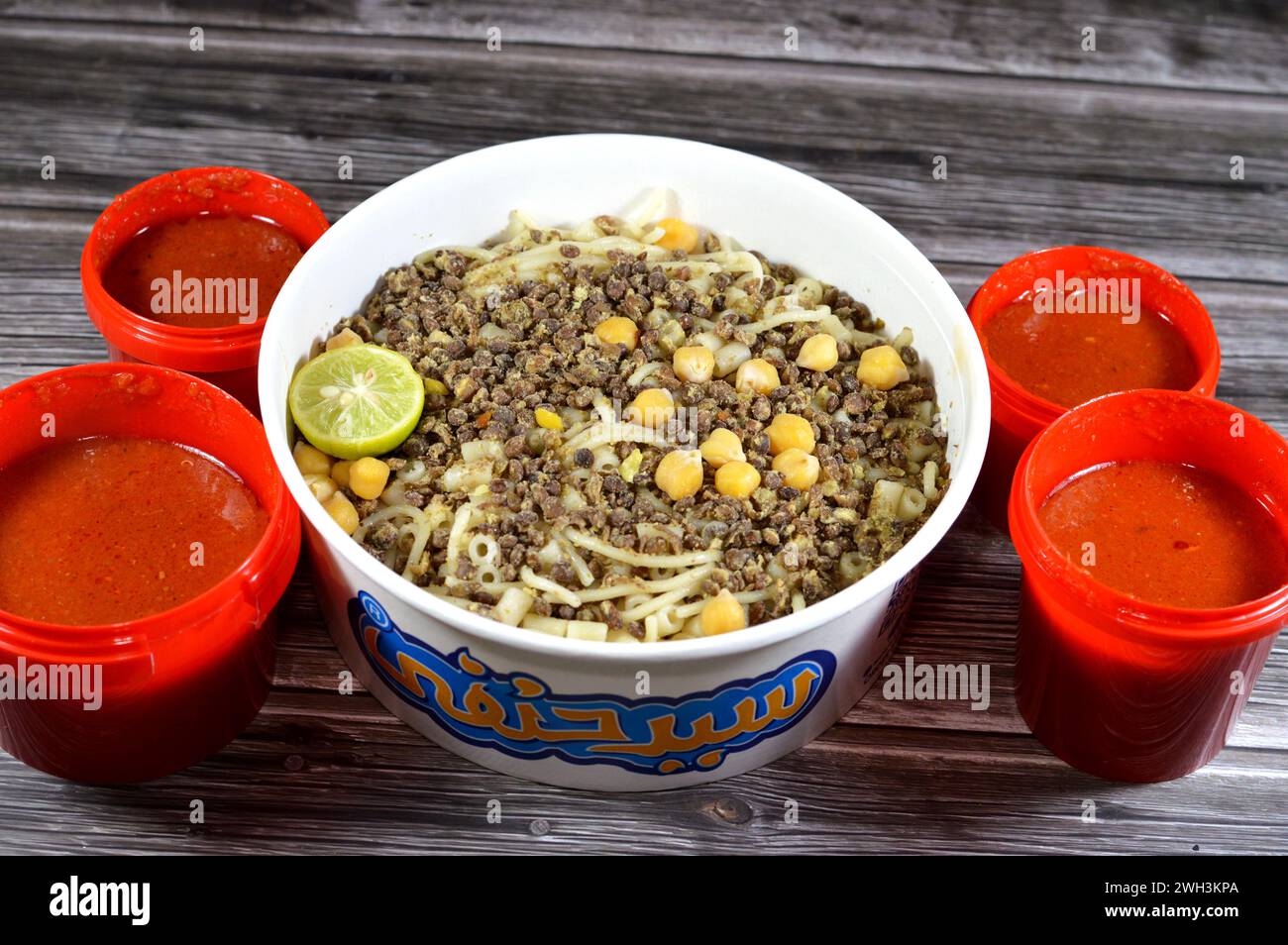 Cairo, Egypt, February 5 2024: Sayed Hanafy Koshary Koshari, street food of rice, macaroni, spaghetti and lentils mixed topped with a spiced tomato sa Stock Photo