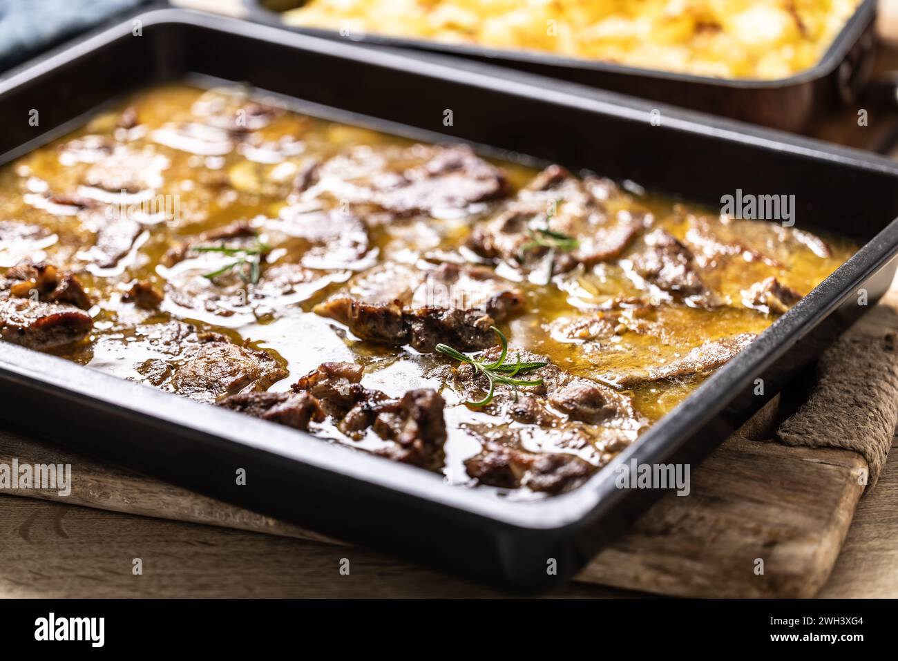 Juicy roasted pork neck with garlic and onion sauce. Stock Photo