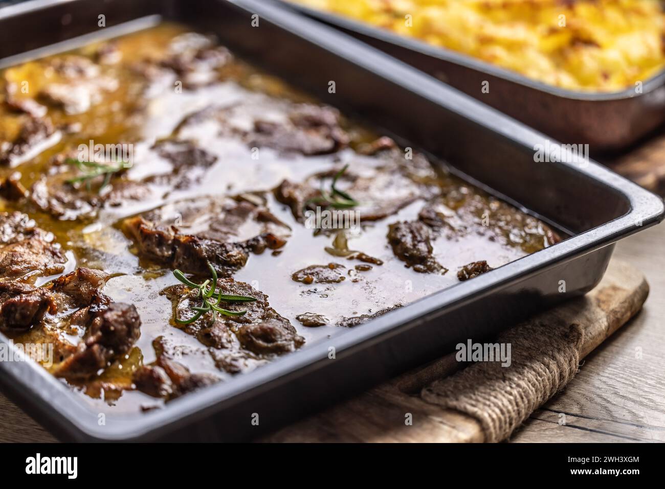 Juicy roasted pork neck with garlic and onion sauce. Stock Photo