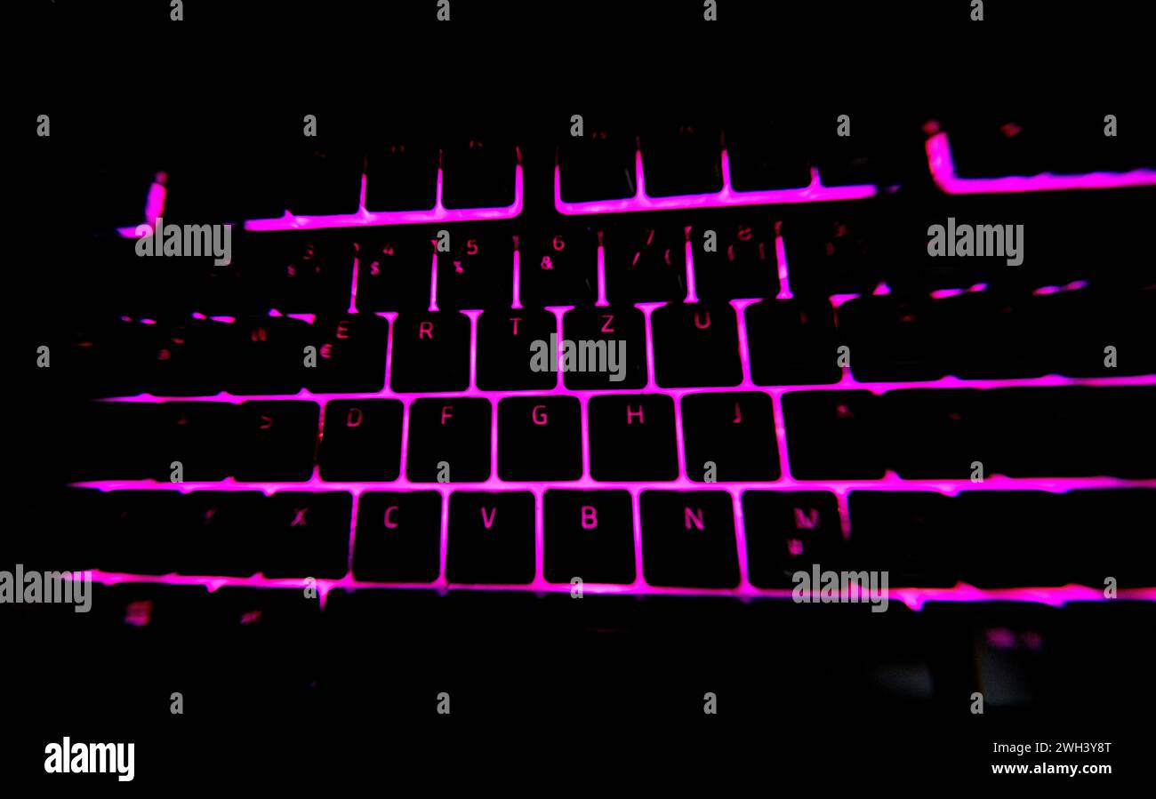 Gaming PC Keyboard illuminated pink color and dark black background ...